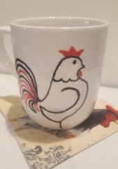 Sharpie mug with rooster design sitting on a mug rug