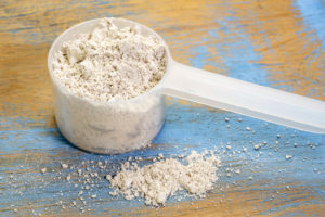 Diatomaceous Earth in a white scoop on rustic blue and gold board