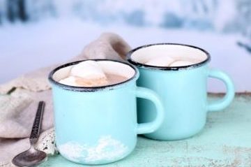 Cocoa in teal mugs on teal board