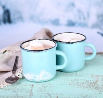 Cocoa in teal mugs on teal board