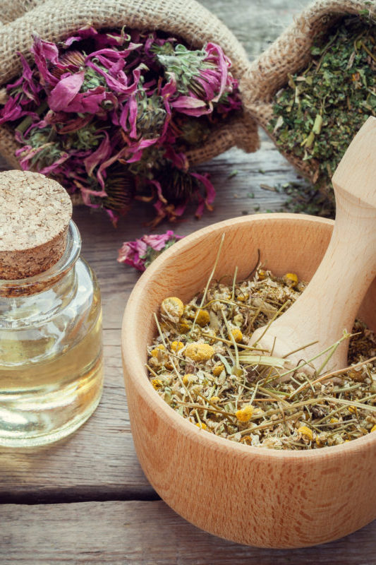 Herbs in wooden mortar with pestle