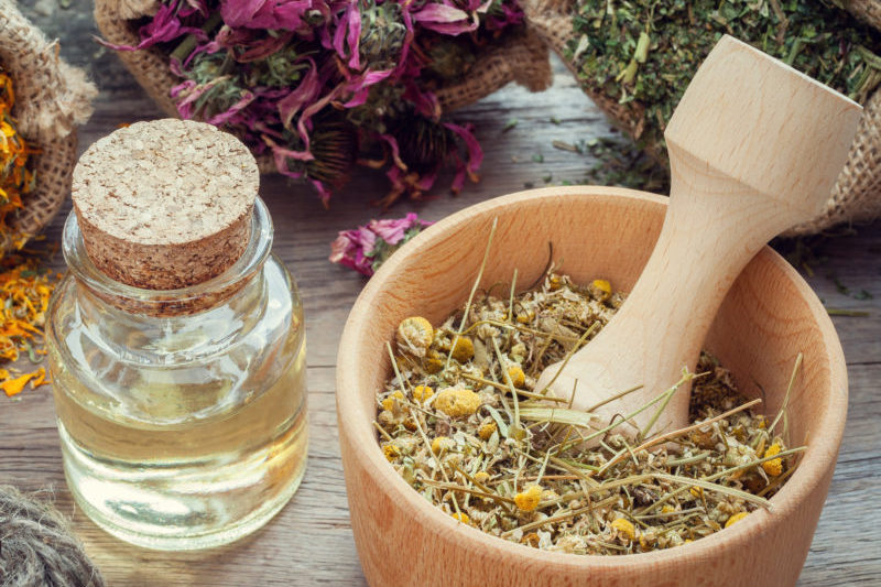 Herbs in wooden mortar with pestle