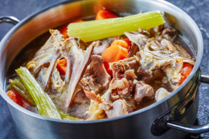 Stock pot with bones and vegetables for stock or broth